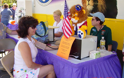Woman getting her blood pressure checked at a Lion's Club table